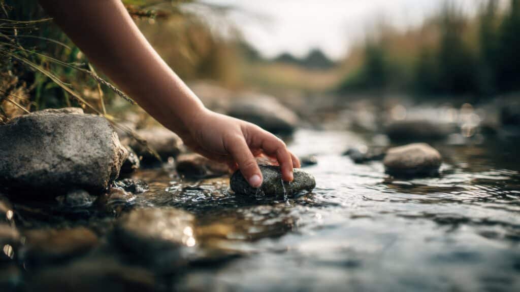 Kind verkent de natuur bij een beekje